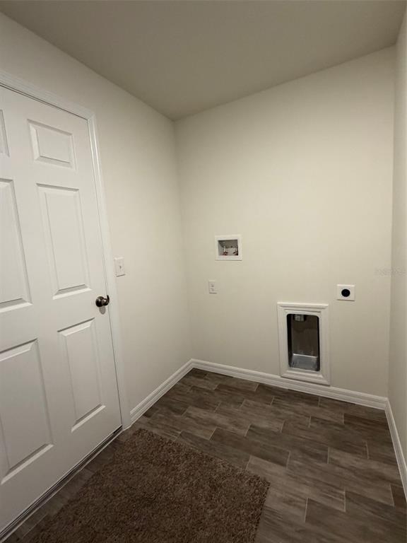 A laundry room features wood-look tile flooring, white walls, and washer and dryer hookups — 904 HUDSON VALLEY DRIVE, POINCIANA, FL