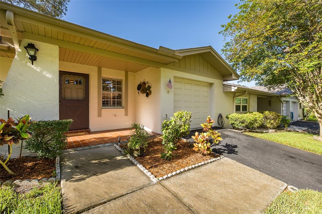 A single-story house features a brown front door, a garage, and a concrete driveway — 2207 MARSHALL DRIVE, DUNEDIN, FL
