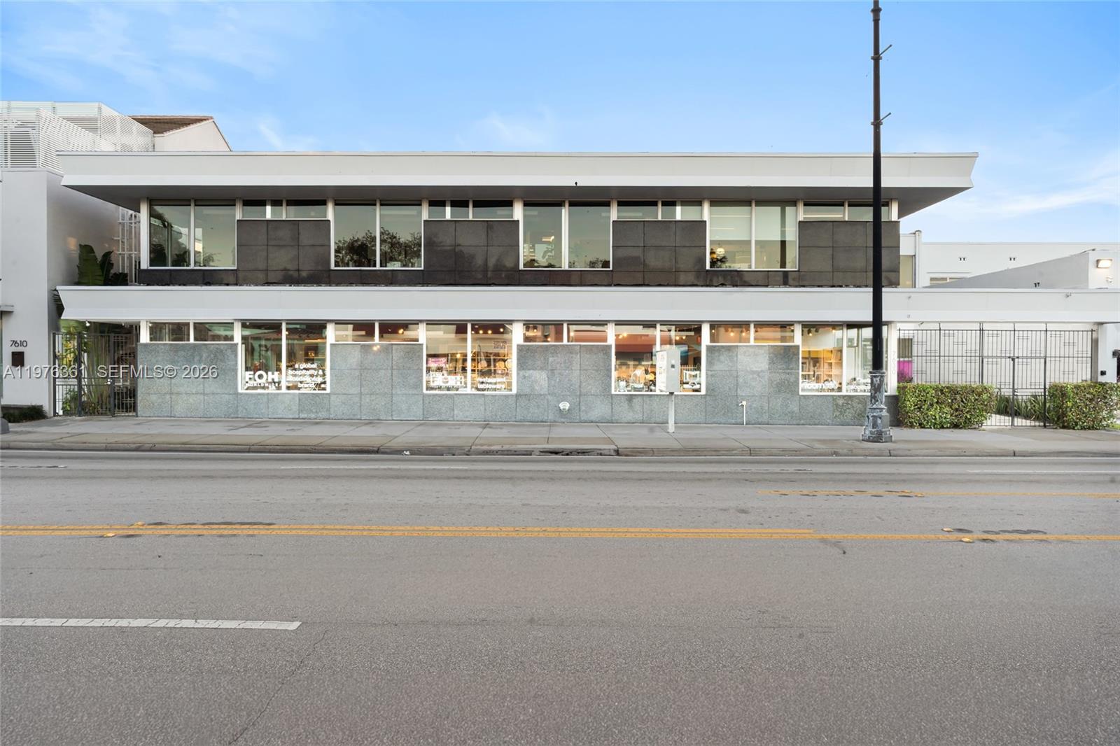 A two-story commercial building features a gray stone facade and large glass windows — 7630 Biscayne Blvd, Miami FL 33138, MIAMI, FL
