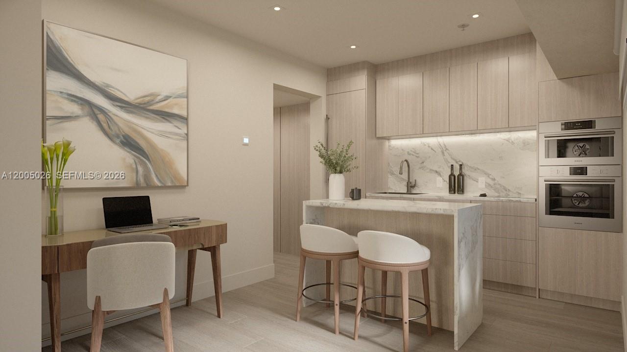 This rendering shows a modern kitchen with light wood cabinetry, marble countertops, and a desk — 260 Collins Ave # 205, Miami Beach FL 33139, MIAMI BEACH, FL