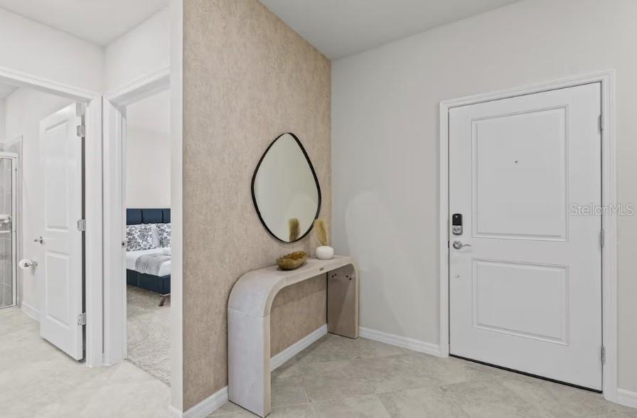 An entryway features a console table, an oval mirror, and a white door — 1145 BLUE ISLAND DRIVE, CLERMONT, FL