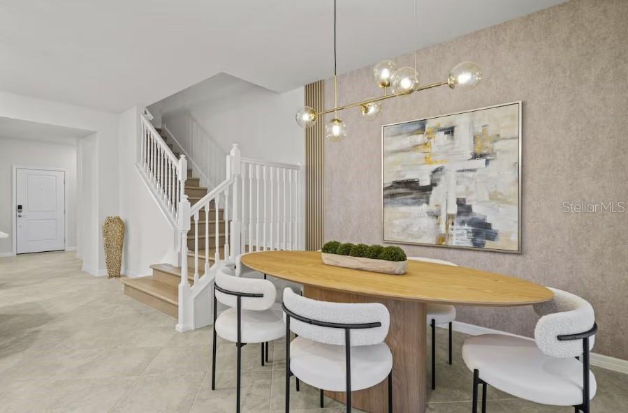 A dining area features an oval wooden table, modern chairs, and a contemporary chandelier — 1145 BLUE ISLAND DRIVE, CLERMONT, FL