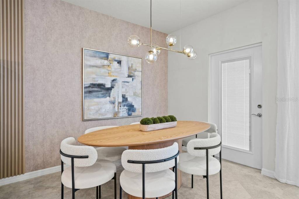 A dining room features an oval wooden table, modern chairs, and a textured accent wall — 1145 BLUE ISLAND DRIVE, CLERMONT, FL