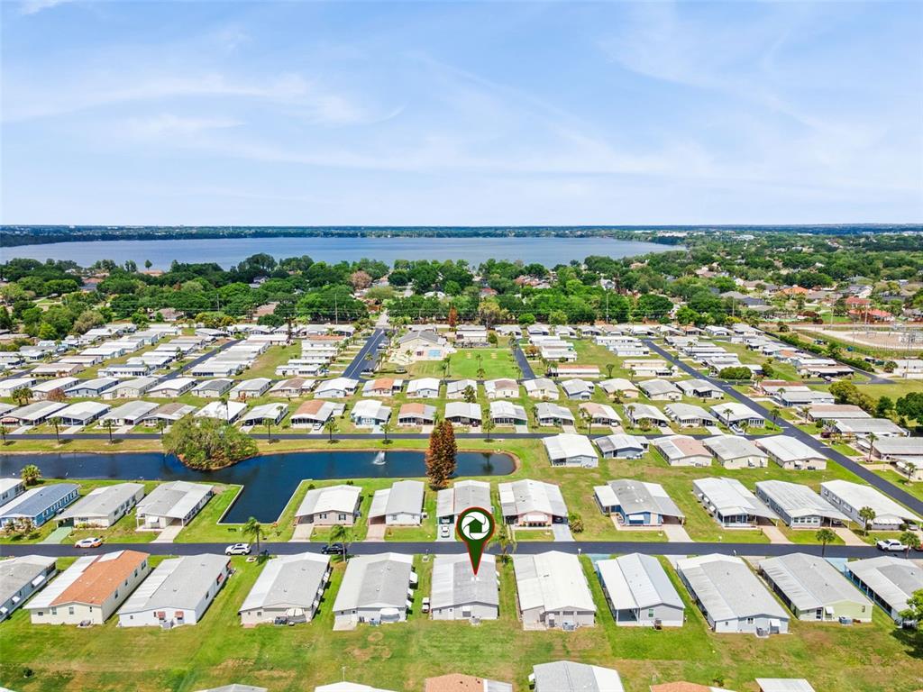 An aerial view shows a residential community of manufactured homes near a large lake — 125 LAKE HAZEL DRIVE, WINTER HAVEN, FL