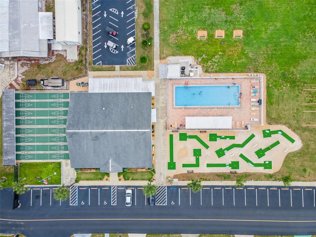 An aerial view shows a building with a pool, miniature golf course, and parking lot — 125 LAKE HAZEL DRIVE, WINTER HAVEN, FL