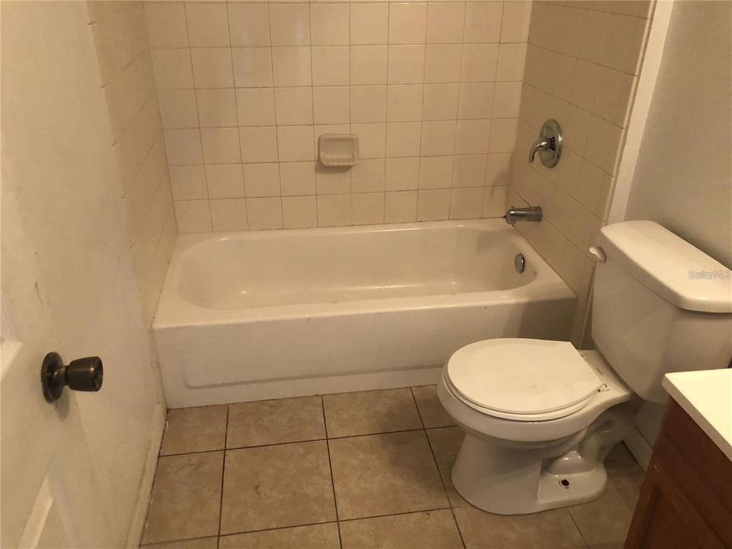 A bathroom features a white bathtub, a tiled shower surround, and a white toilet — 325 BACCARAT COURT UNIT B, KISSIMMEE, FL