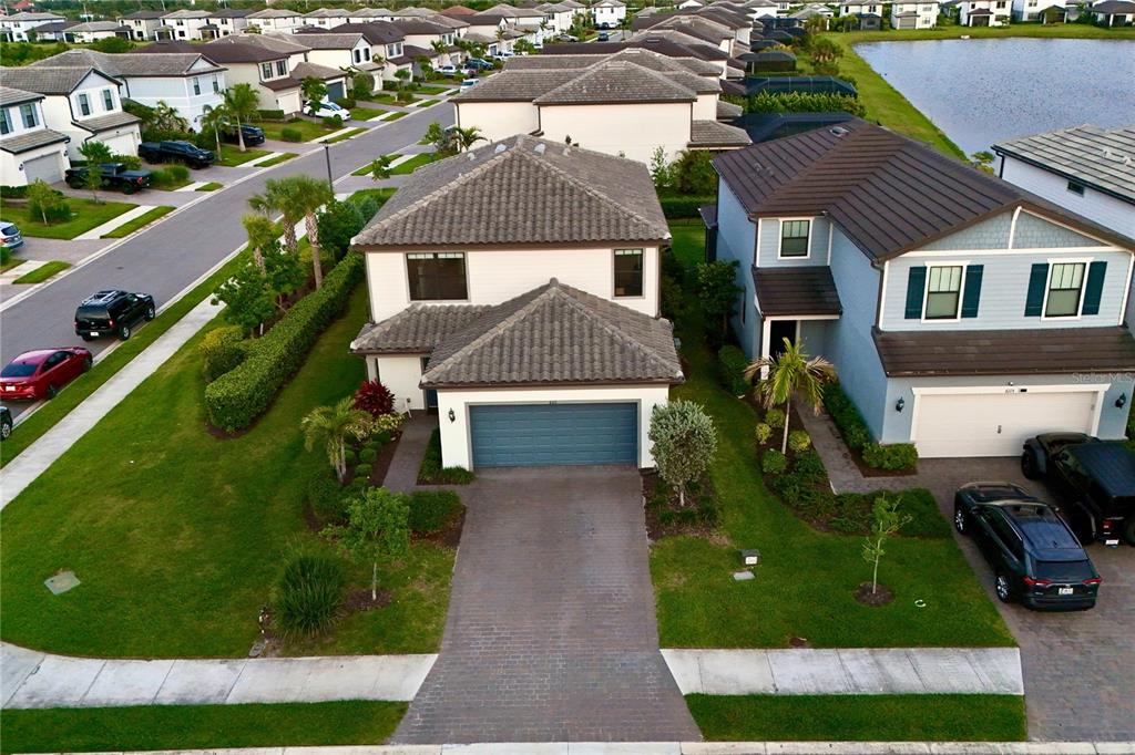 An aerial view shows a two-story suburban house with a tiled roof and paved driveway — 6111 BLUESTAR COURT, BRADENTON, FL