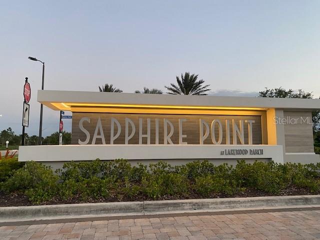 A modern entrance sign for Sapphire Point at Lakewood Ranch stands outdoors at dusk — 6111 BLUESTAR COURT, BRADENTON, FL