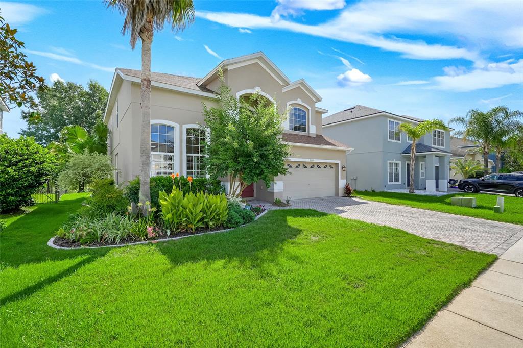 A two-story suburban house with a beige stucco exterior, a paved driveway, and a front lawn — 33519 TERRAGONA DRIVE, SORRENTO, FL