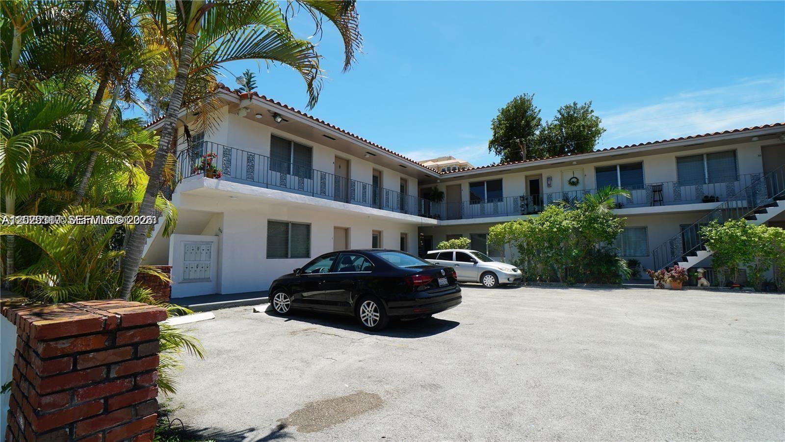 A two-story apartment building with a parking lot and palm trees in front — 236 Madeira Ave # 6, Coral Gables FL 33134, CORAL GABLES, FL