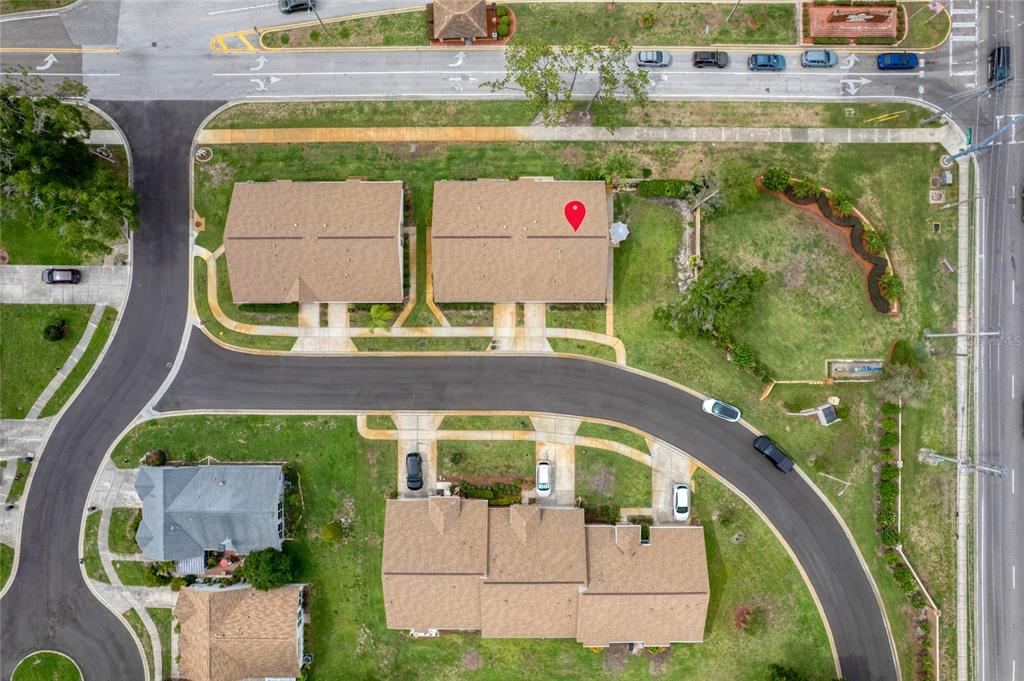 This aerial view shows a residential neighborhood with houses, driveways, and a curved road — 9022 RAMSGATE DRIVE UNIT 9022, NEW PORT RICHEY, FL