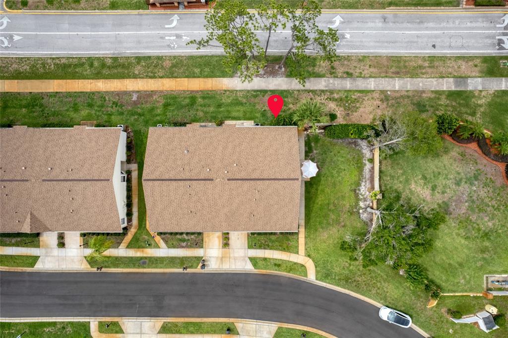 An aerial view shows two townhomes with brown roofs, a road, and a red location pin — 9022 RAMSGATE DRIVE UNIT 9022, NEW PORT RICHEY, FL