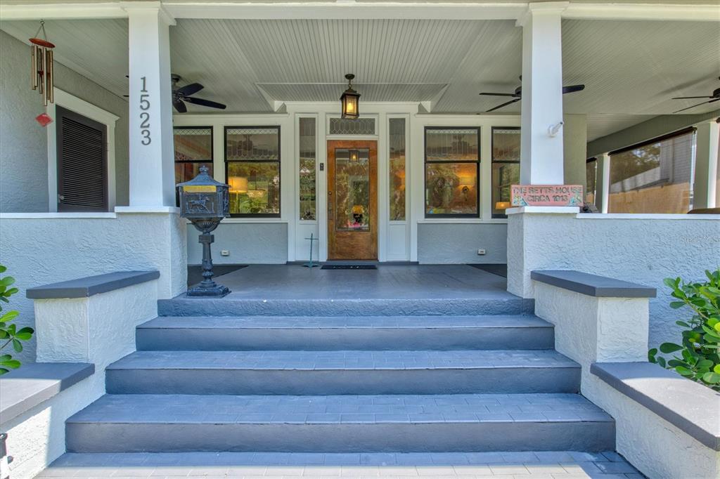 A front porch with gray steps, a wooden door, and a black pedestal mailbox — 1523 1ST AVENUE W, BRADENTON, FL