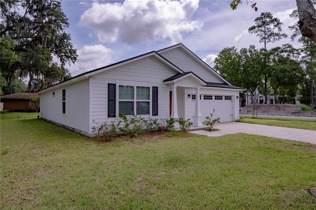 A white, single-story house with a front-facing garage and a small covered entryway — 805 TURTLE CREEK DRIVE S, JACKSONVILLE, FL