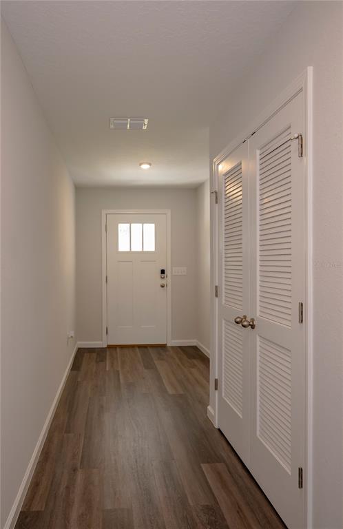 A hallway features wood-look flooring, a white front door, and a white louvered closet door — 805 TURTLE CREEK DRIVE S, JACKSONVILLE, FL