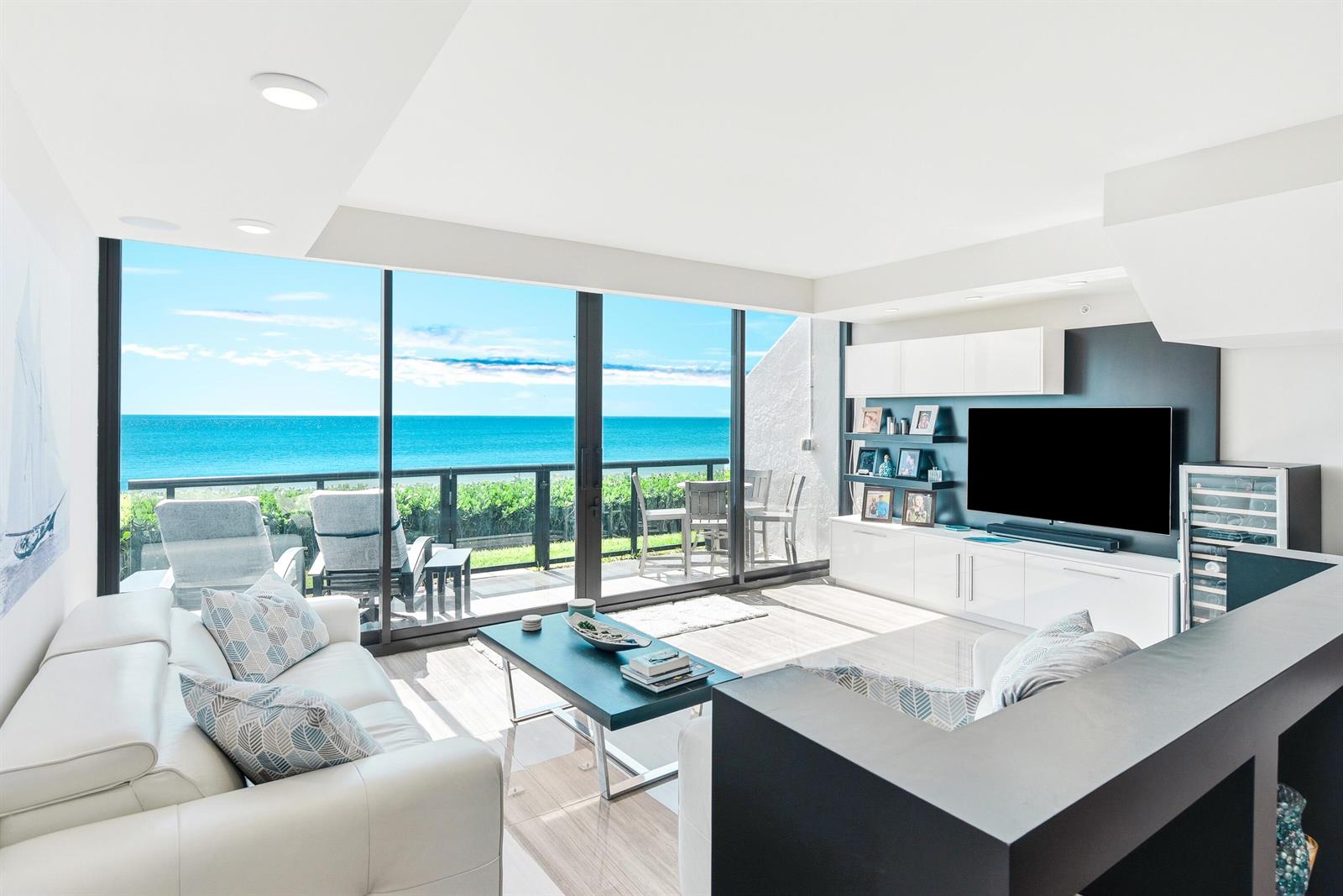 A modern living room features a white sofa, a black coffee table, and ocean views — 3115 S Ocean Boulevard # 103, Highland Beach FL 33487, HIGHLAND BEACH, FL