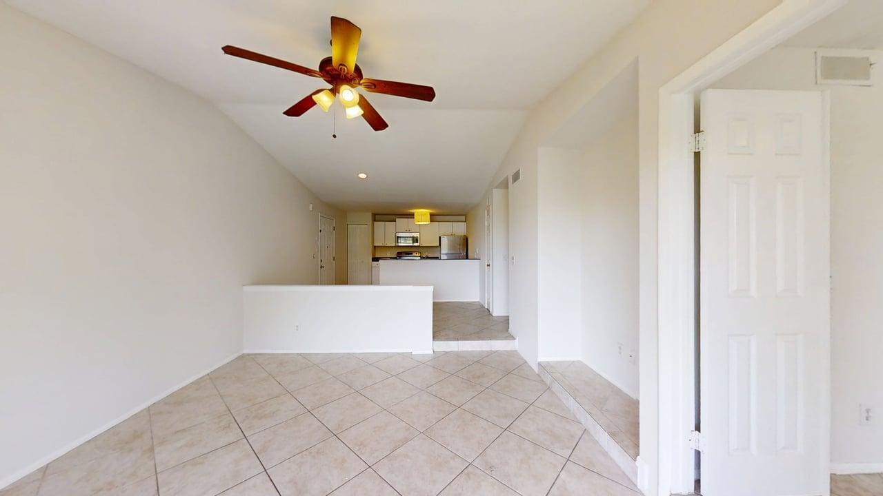 A tiled dining area leads to a kitchen with white cabinets and a ceiling fan — 1885 Palm Cove Boulevard # 307, Delray Beach FL 33445, DELRAY BEACH, FL