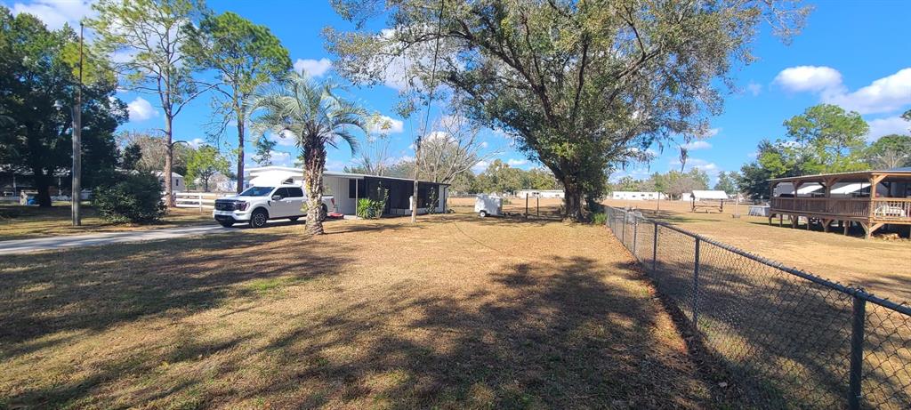 A white pickup truck is parked next to a mobile home on a grassy lot — 37021 PAULS DRIVE, ZEPHYRHILLS, FL