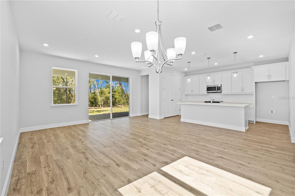 A bright, open-concept kitchen and living area features white cabinetry, a central island, and flooring — 5034 W PINTO LOOP, BEVERLY HILLS, FL