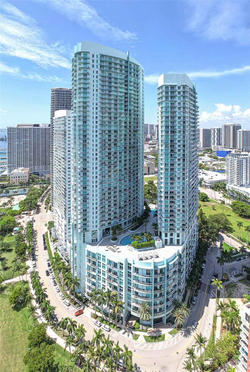 An aerial view of two tall, light-blue residential towers with a shared pool deck below — 1900 N BAYSHORE DR, Miami FL 33132, MIAMI, FL