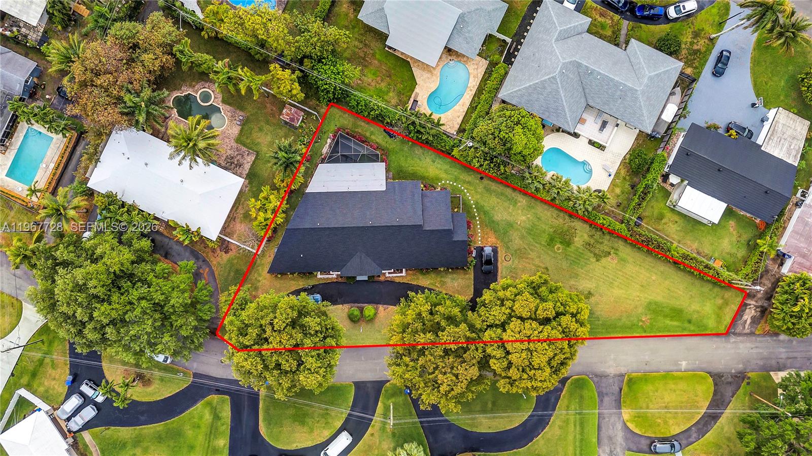 An aerial view shows a house with a dark roof on a large, landscaped lot — 3211 Calle Largo Dr, Hollywood FL 33021, HOLLYWOOD, FL