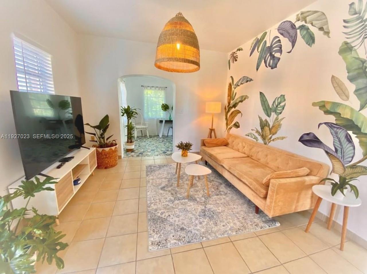 A living room features a tan sofa, a botanical wall mural, and a woven pendant light — 1872 SW 9th St, Miami FL 33135, MIAMI, FL