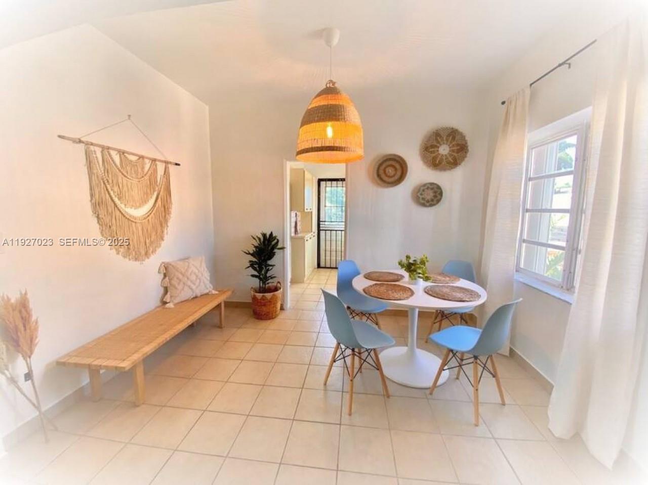 A dining room features a round white table, four blue chairs, and a wooden bench — 1872 SW 9th St, Miami FL 33135, MIAMI, FL
