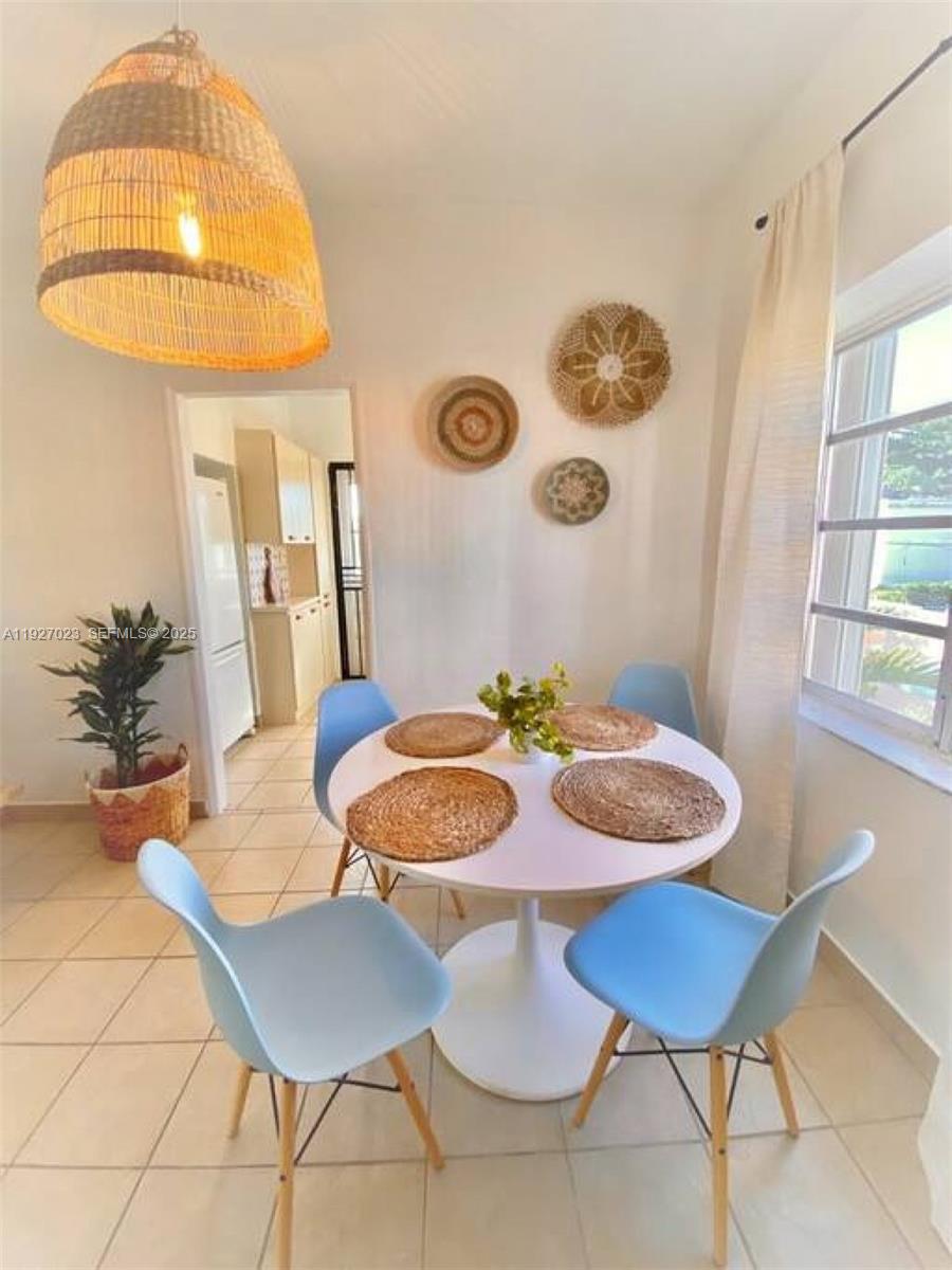 A dining area features a white round table, four blue chairs, and woven wall decor — 1872 SW 9th St, Miami FL 33135, MIAMI, FL
