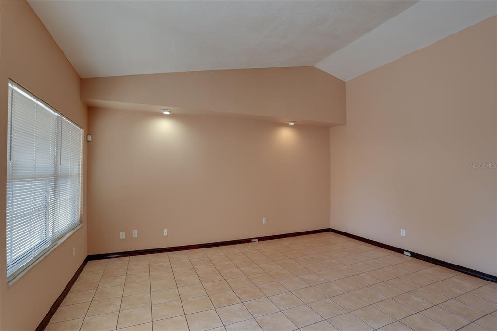 An empty room with beige walls, tile flooring, a vaulted ceiling, and recessed lighting — 492 TAMARACK STREET, ALTAMONTE SPRINGS, FL