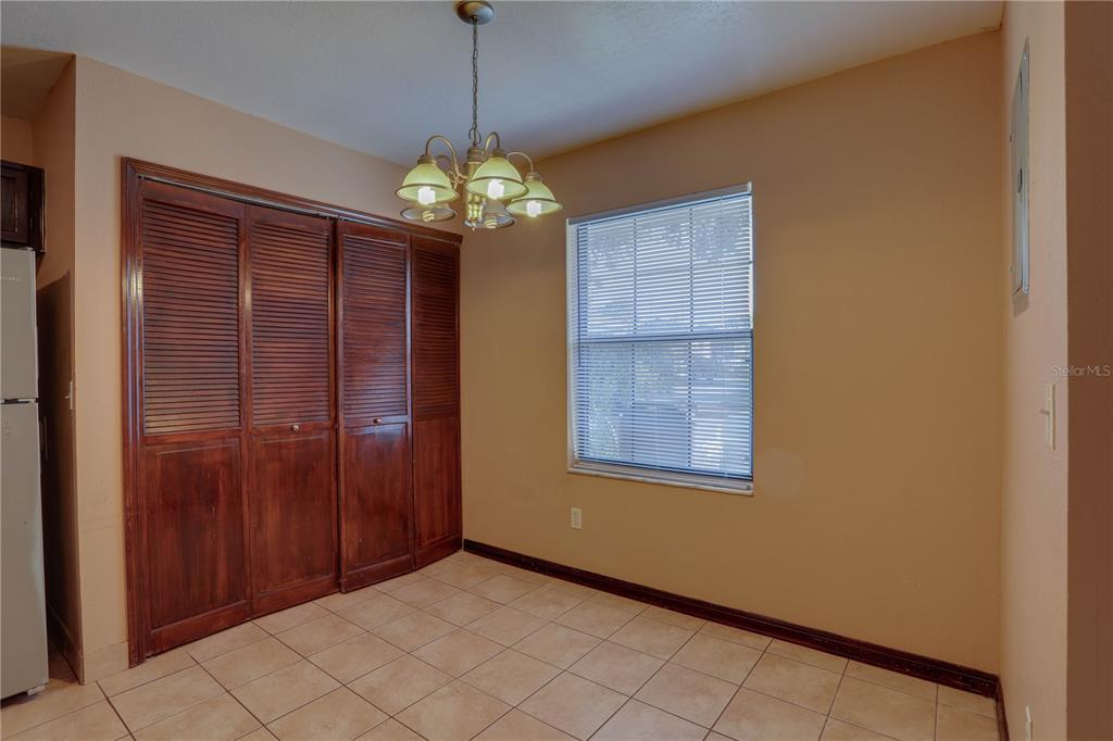 A dining area features a louvered closet, tile flooring, and a hanging light fixture — 492 TAMARACK STREET, ALTAMONTE SPRINGS, FL