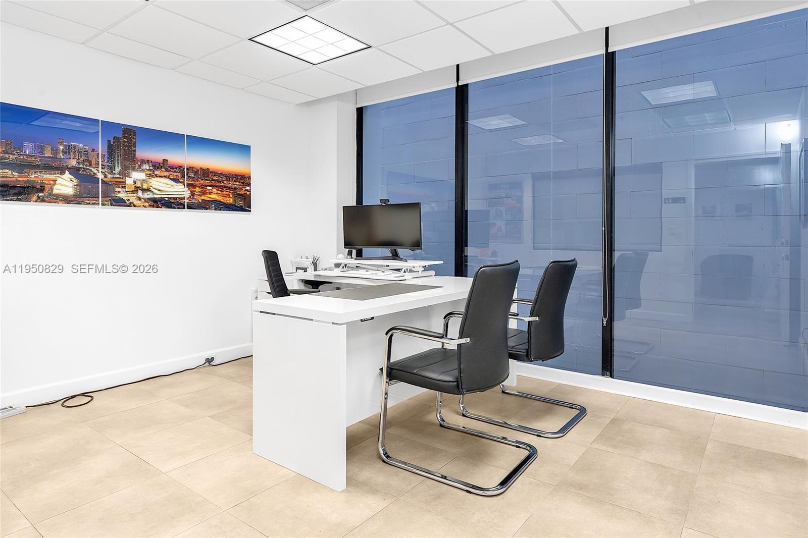 A modern office features a white desk, two black chairs, and a city skyline wall art — 1110 Brickell Ave # 806, Miami FL 33131, MIAMI, FL