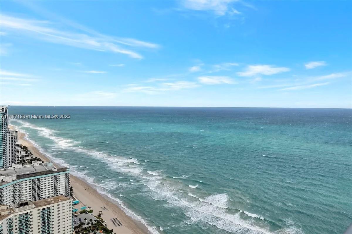 An elevated view of a sandy beach and the ocean under a blue sky — 4111 S Ocean Dr, Hollywood FL 33019, HOLLYWOOD, FL