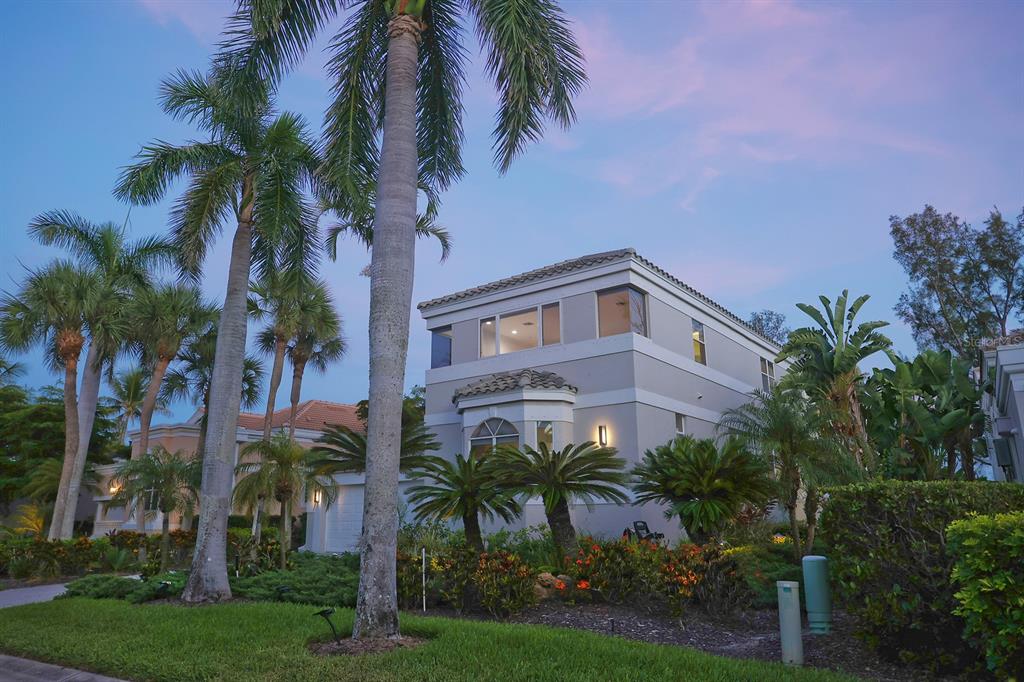 A two-story house with a light-colored exterior is surrounded by palm trees and landscaping — 3527 FAIR OAKS LANE, LONGBOAT KEY, FL