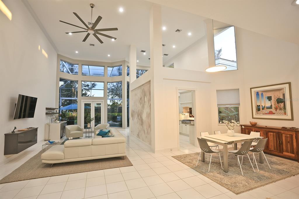 A bright, open-concept living and dining area features high ceilings, tile floors, and large windows — 3527 FAIR OAKS LANE, LONGBOAT KEY, FL