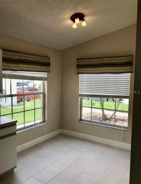 A dining area with tile flooring, two windows with striped shades, and a ceiling light fixture — 333 PICCOLO WAY, DAVENPORT, FL