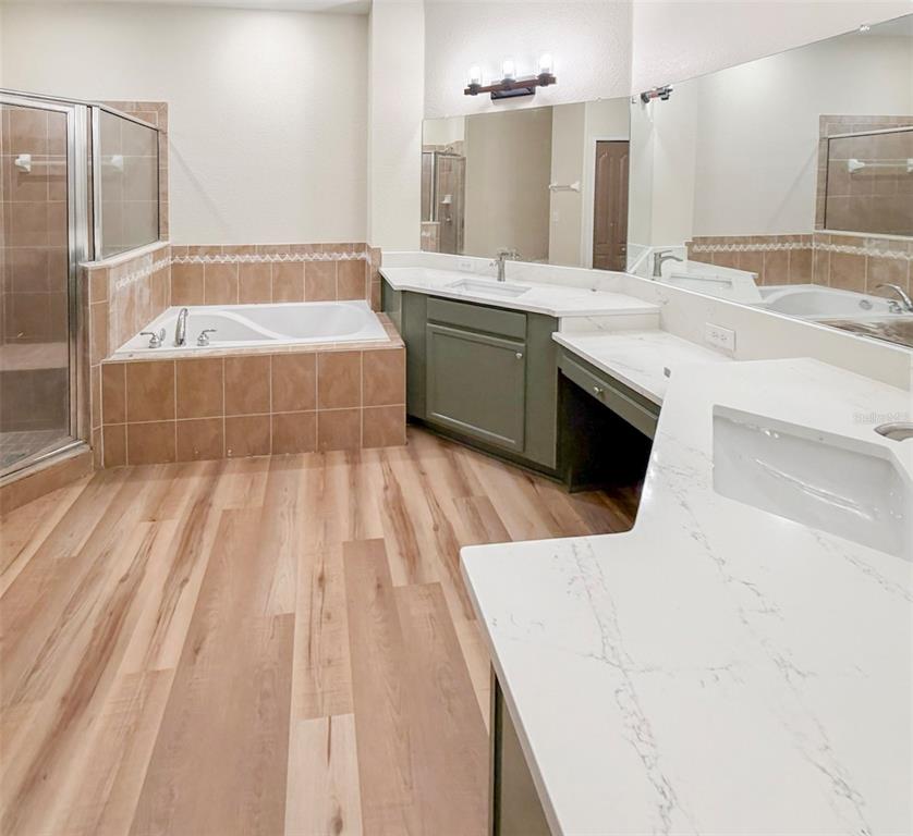 A bathroom features a tiled soaking tub, a glass shower, and a dual-sink vanity — 5014 YELLOWTOP LOOP, LAKELAND, FL