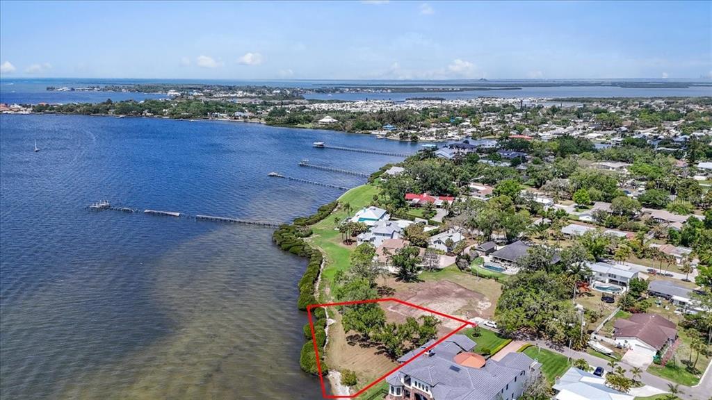 An aerial view shows a vacant waterfront lot outlined in red next to a house — 2111 4TH ST COURT W, PALMETTO, FL