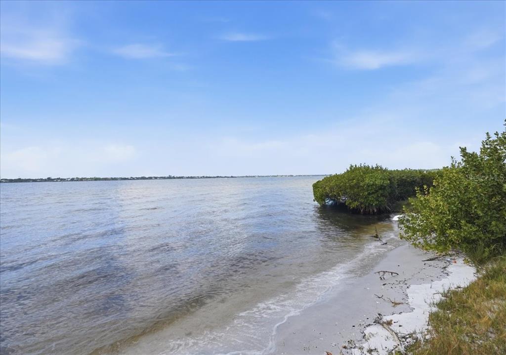 A sandy beach meets a calm body of water with mangroves on the left side — 2111 4TH ST COURT W, PALMETTO, FL