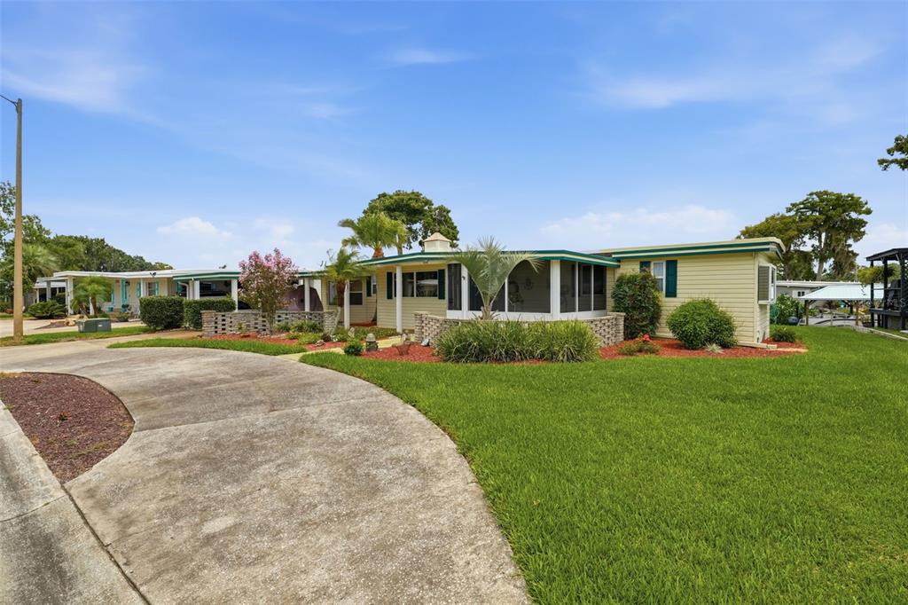 A single-story house with yellow siding, a screened-in porch, and a concrete driveway — 928 MORNINGVIEW DRIVE, TAVARES, FL