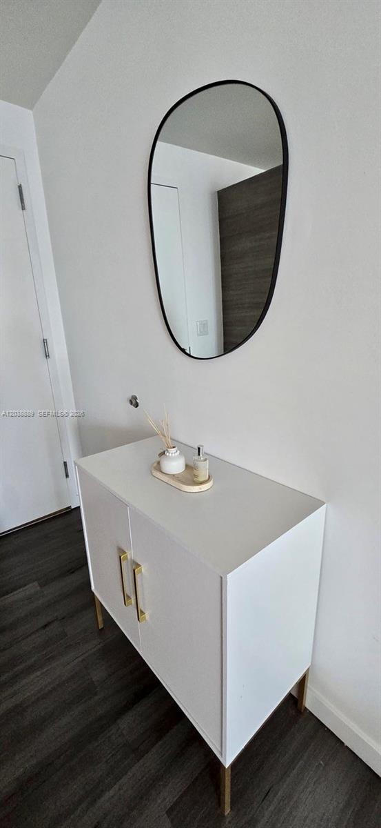 A white cabinet with gold handles sits beneath an oval mirror on a white wall — 1100 S Miami Ave # 3808, Miami FL 33130, MIAMI, FL