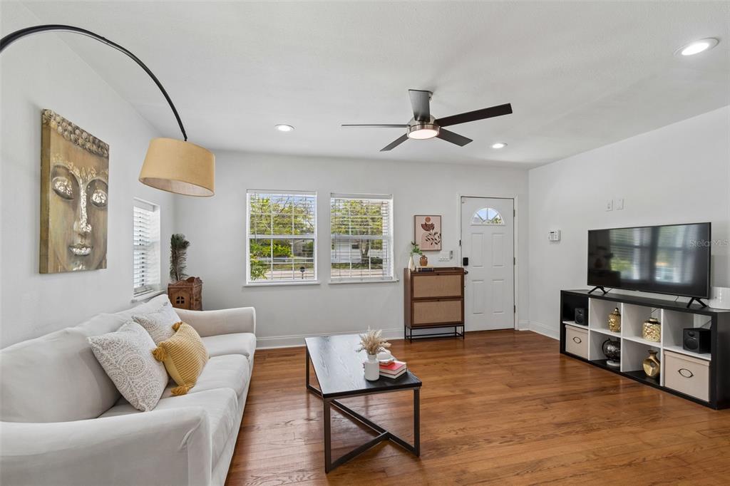 A living room features a white sofa, a black coffee table, and a television console — 2801 S MANHATTAN AVENUE, TAMPA, FL