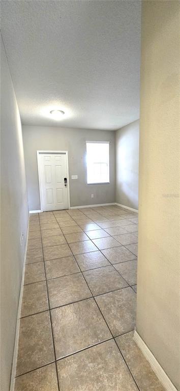 A room with light-colored walls, a white door, a window, and tan tile flooring — 10797 SAVANNAH LANDING CIRCLE, ORLANDO, FL