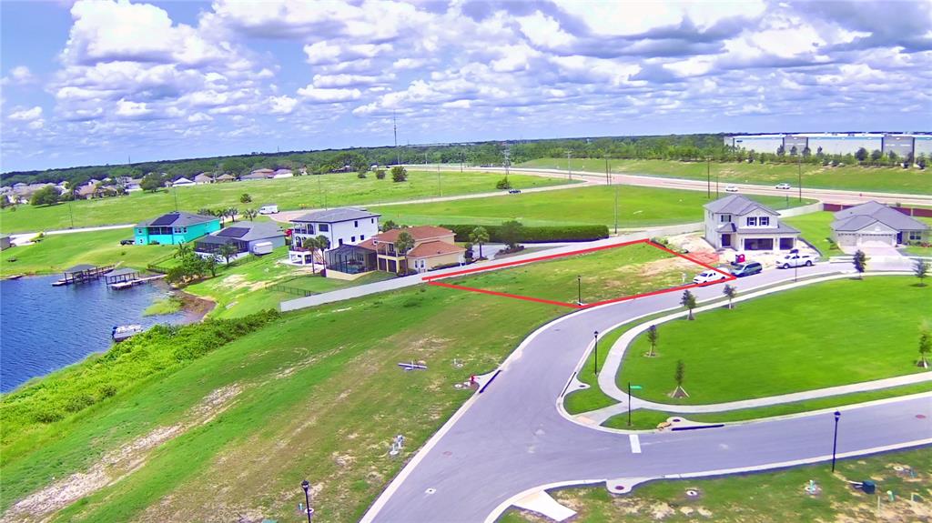 An aerial view shows a vacant residential lot outlined in red within a suburban neighborhood — 4401 JULIANA LAKE DRIVE, AUBURNDALE, FL