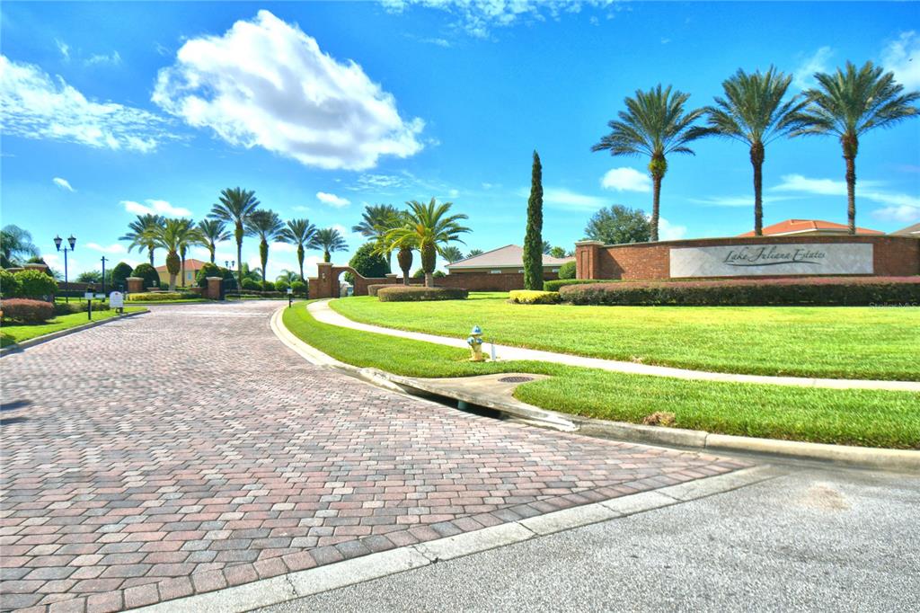 A brick-paved road leads to the entrance sign of Lake Juliana Estates with palm trees — 4401 JULIANA LAKE DRIVE, AUBURNDALE, FL