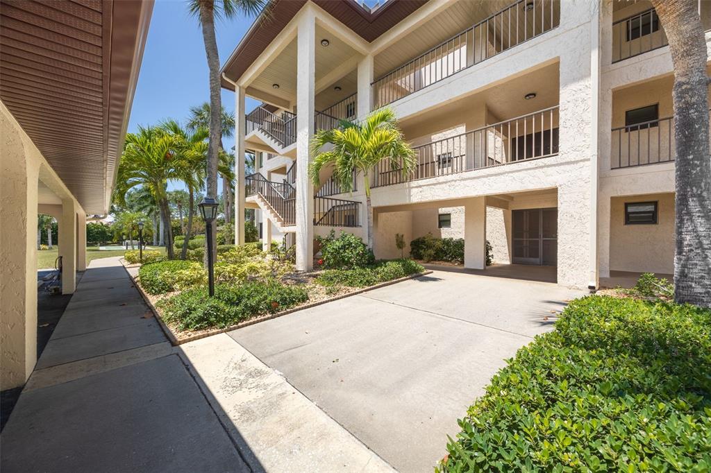A multi-story apartment building with exterior staircases, balconies, and a concrete driveway — 3 PIRATES LANE UNIT 32A, PUNTA GORDA, FL