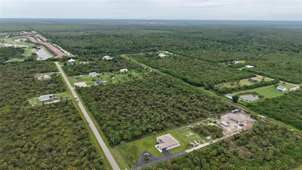 An aerial view shows scattered houses situated among dense vegetation and undeveloped land — 39TH AVENUE NW, NAPLES, FL