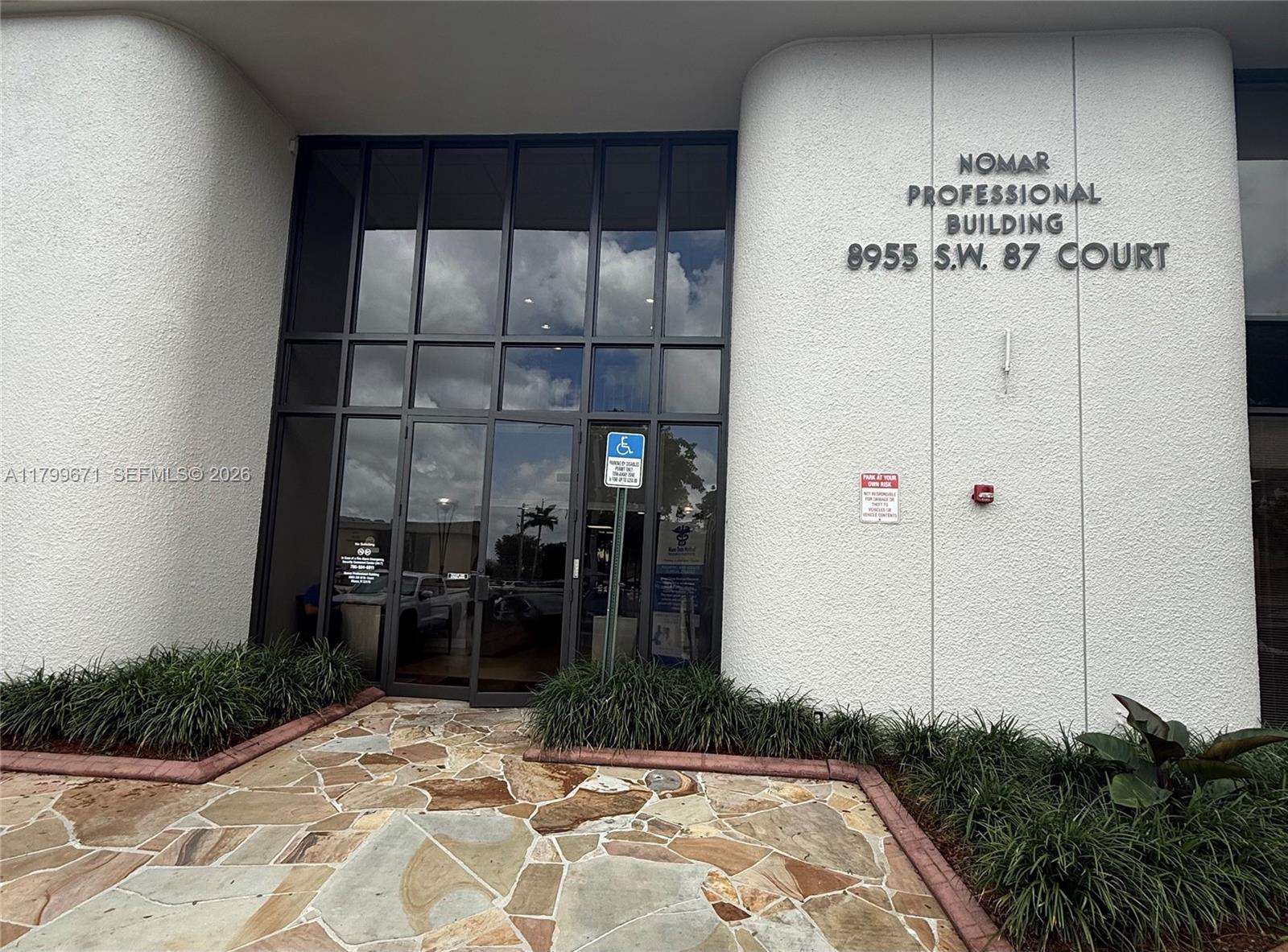 The exterior entrance of a professional building features a glass door and stone walkway — 8955 SW 87th Ct # 101, Miami FL 33176, MIAMI, FL