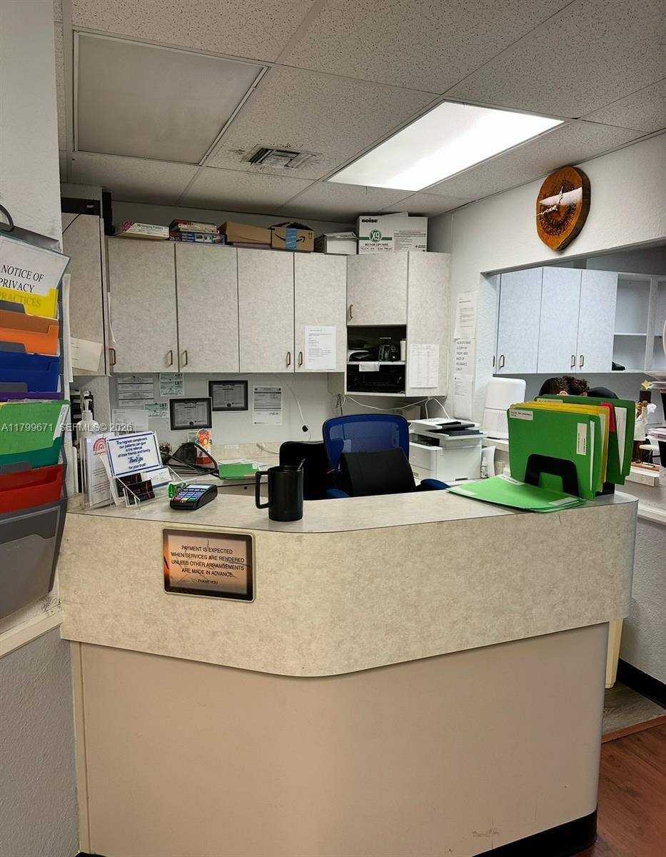 A reception desk with office supplies and cabinets is located in a professional office space — 8955 SW 87th Ct # 101, Miami FL 33176, MIAMI, FL