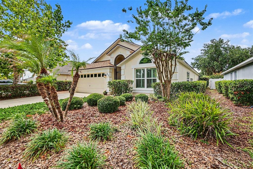 A single-story suburban house with a beige stucco exterior, a garage, and landscaped front yard — 2936 MOORCROFT CT, ORLANDO, FL