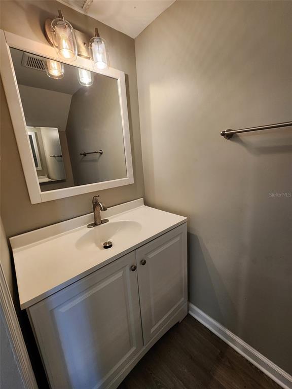 A bathroom features a white vanity with a sink, a mirror, and a wall-mounted towel bar — 701 1ST STREET UNIT 2, INDIAN ROCKS BEACH, FL